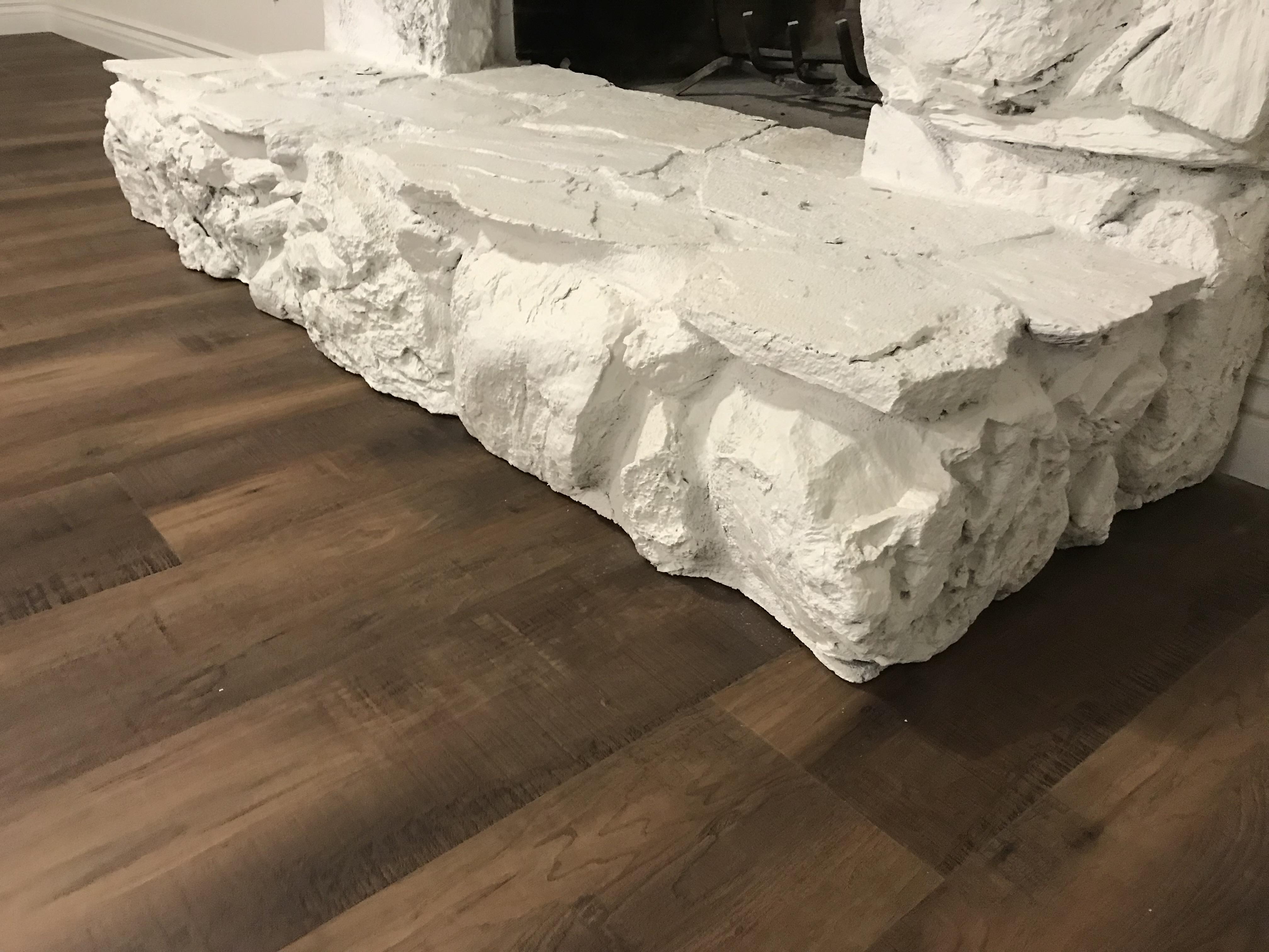 Dark vinyl plank flooring around a stone fireplace in a Sacramento, CA home