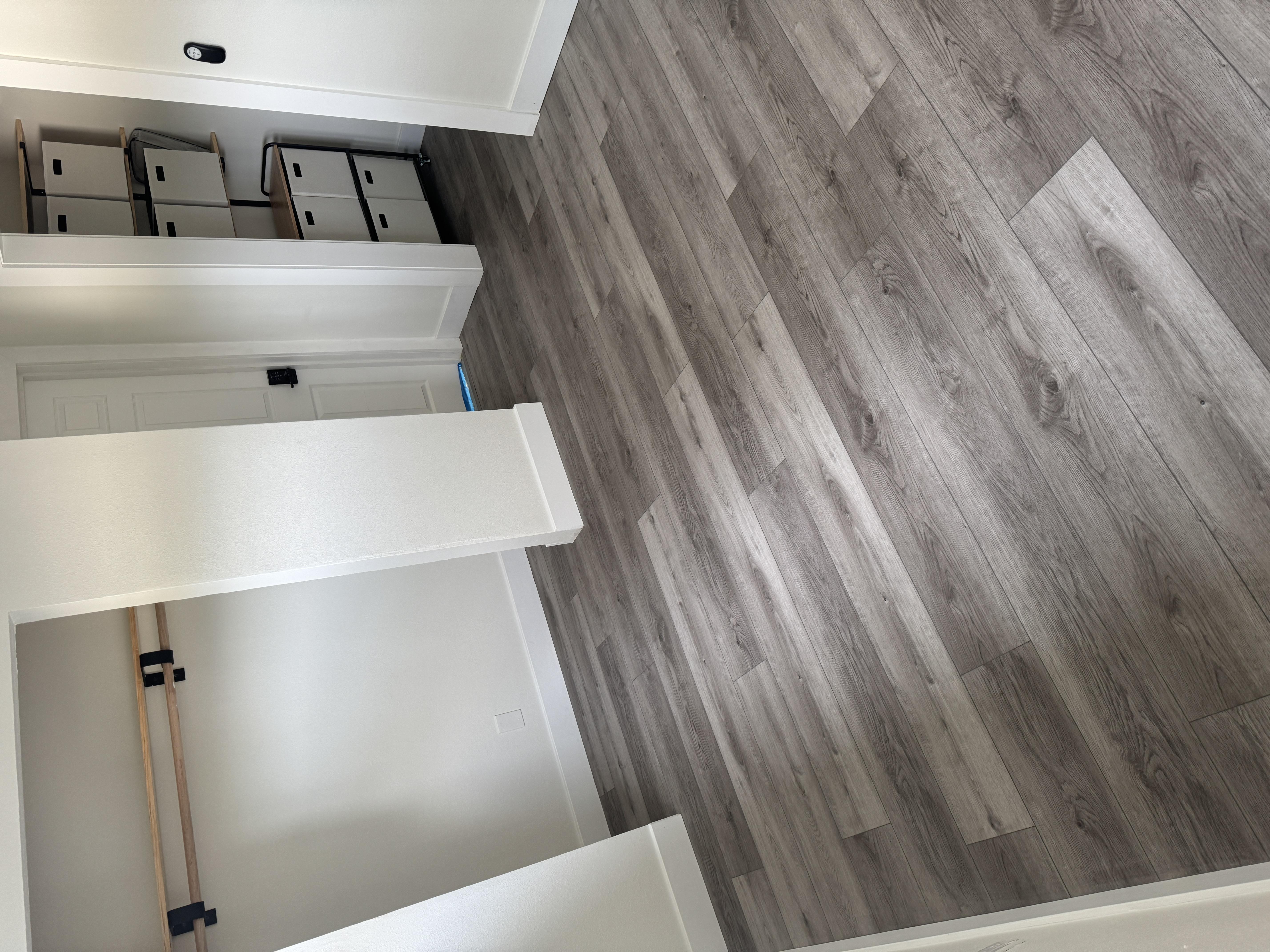Gray luxury vinyl plank flooring through closet and bedroom in a West Roseville, CA home