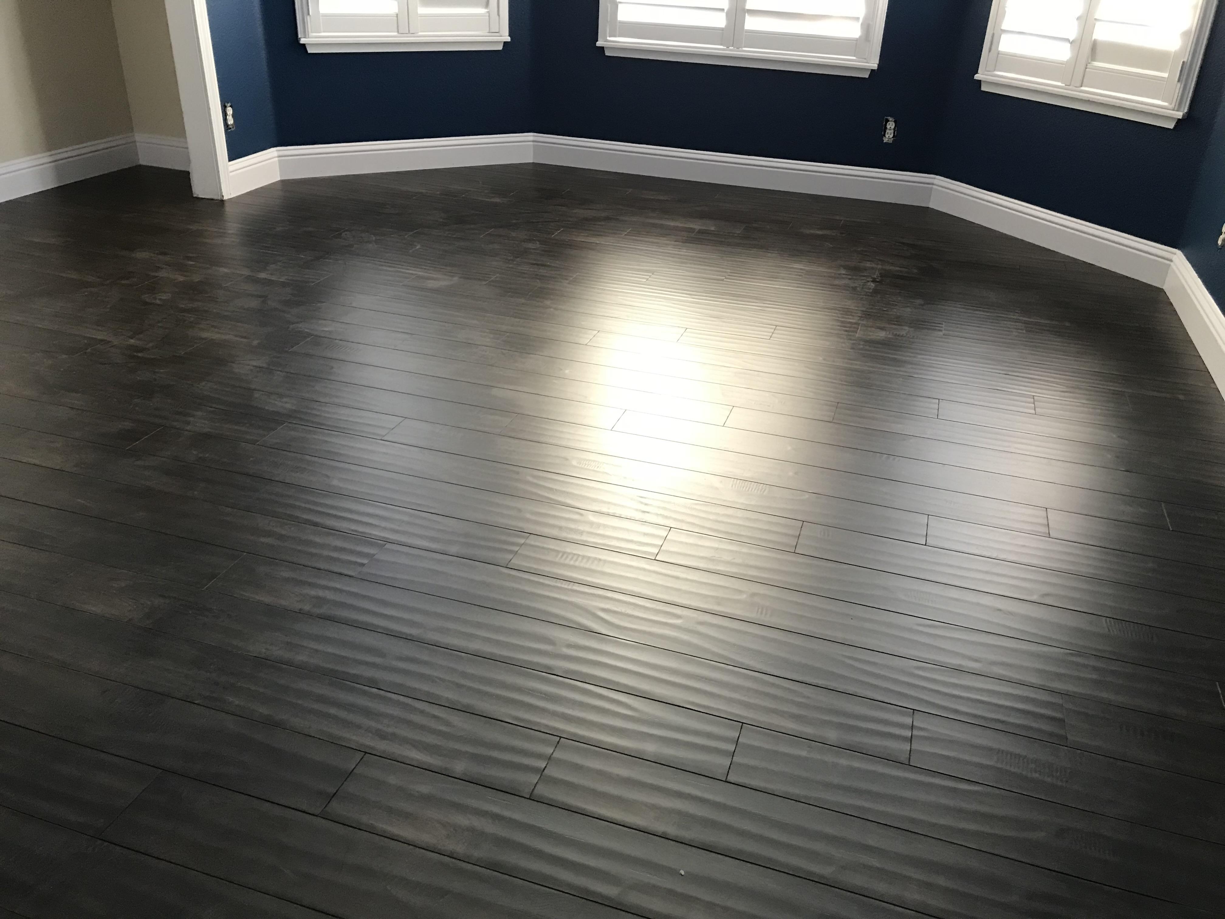 Gray-stained hardwood floor in a navy-walled formal room in a Sacramento, CA home