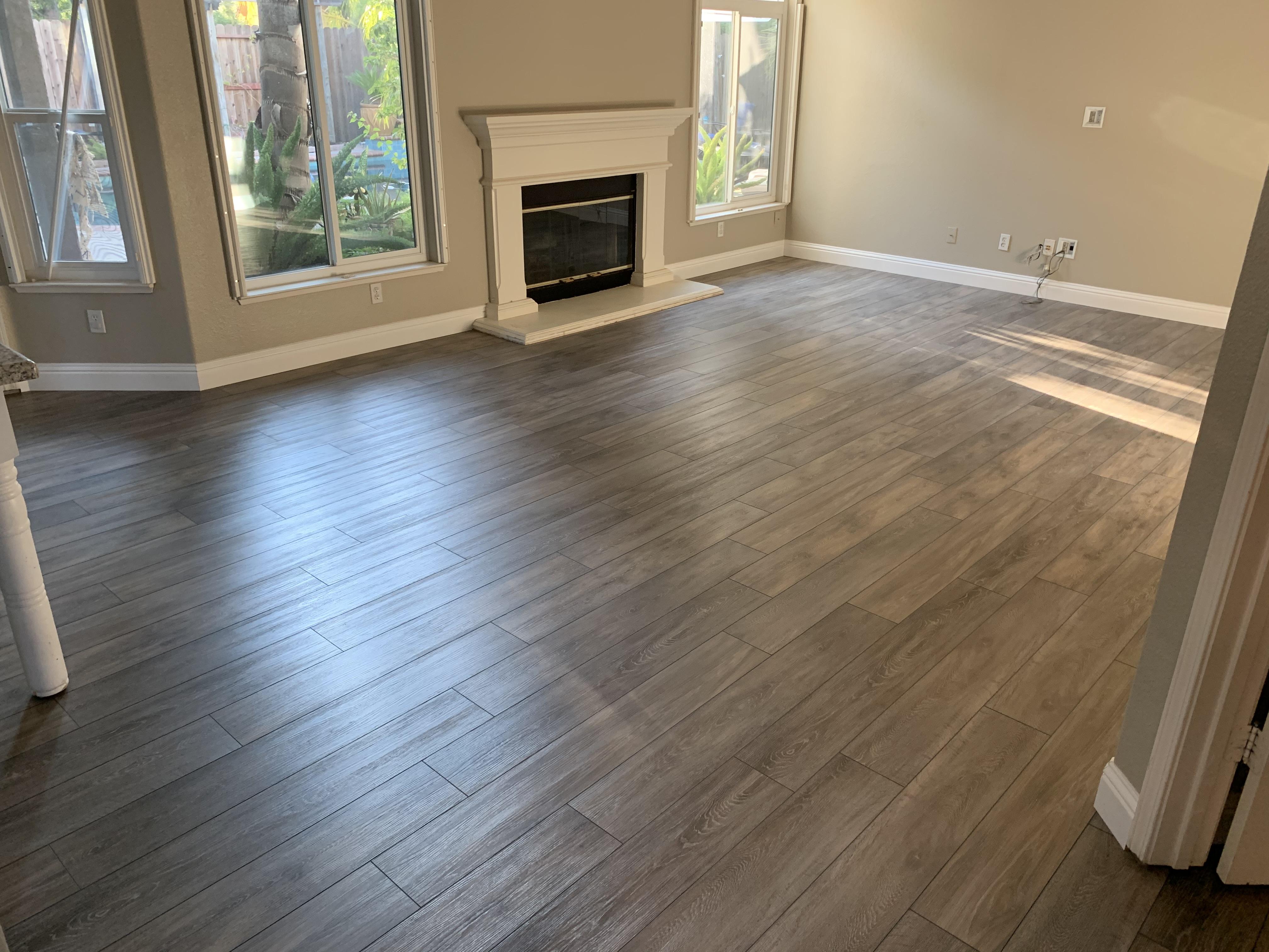 Gray vinyl plank living room floor with stone fireplace in a Folsom, CA home