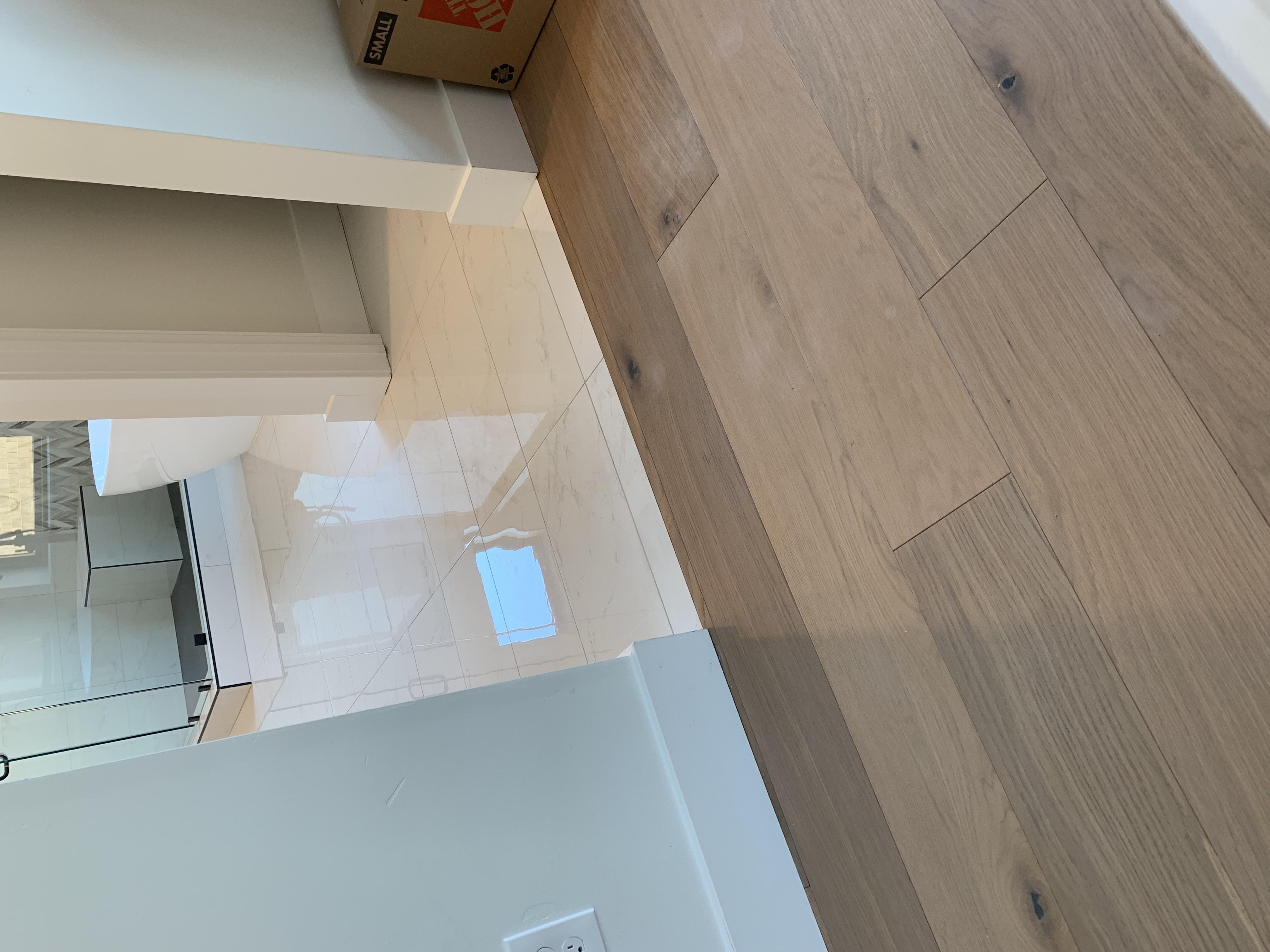 Wide-plank hardwood to marble tile bathroom transition in a Granite Bay, CA home
